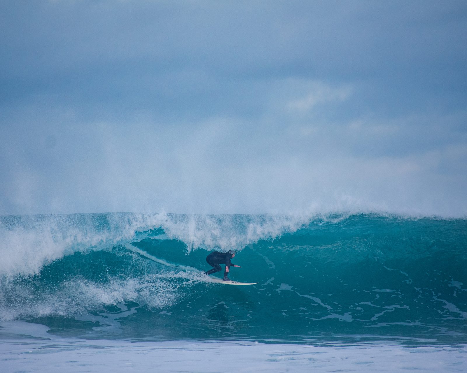 Surfeur au creux d’une vague bleue